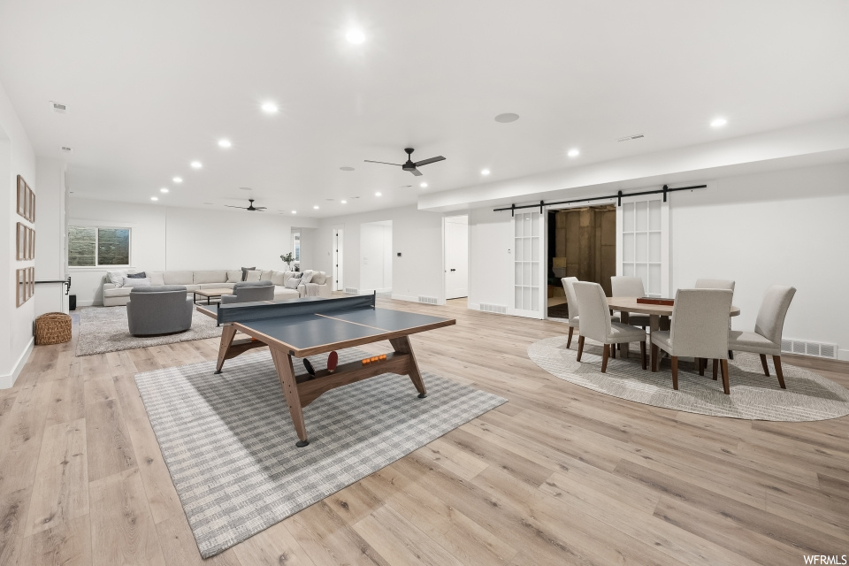 Rec room with ceiling fan and light parquet floors
