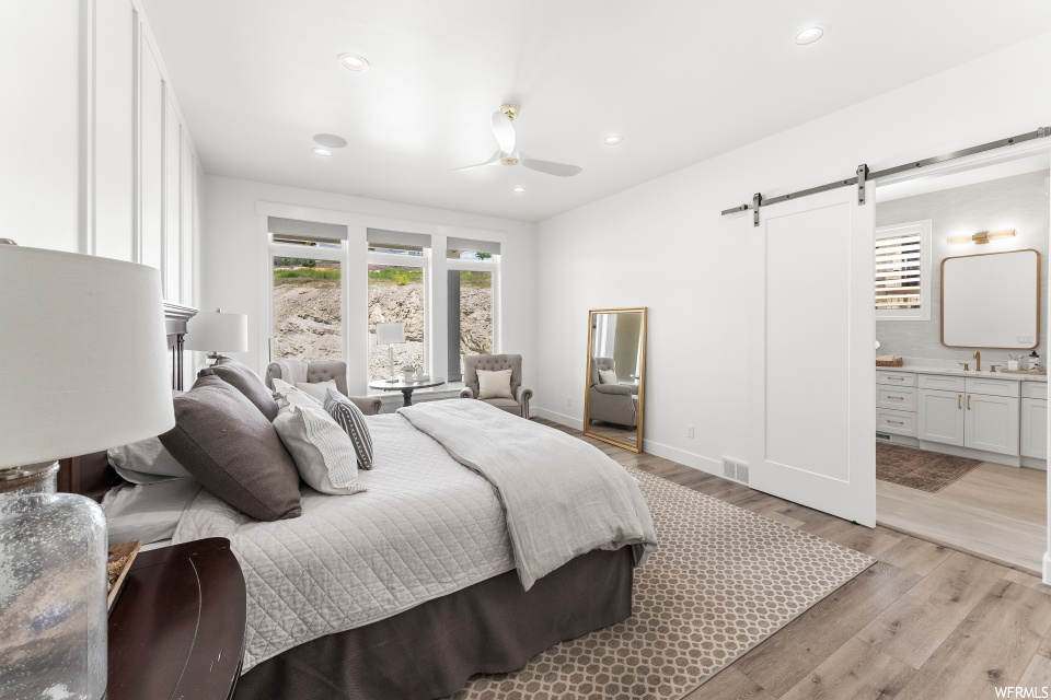 Bedroom featuring a ceiling fan, natural light, and hardwood flooring