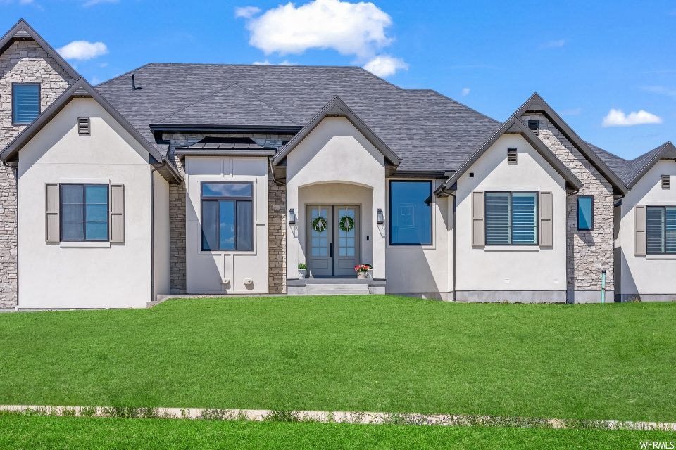 View of front of property featuring a front lawn and french doors