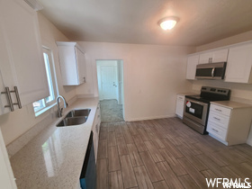 Kitchen featuring range oven, microwave, light parquet floors, and white cabinets