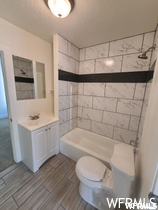 Full bathroom with tile floors, mirror, toilet, washtub / shower combination, and vanity