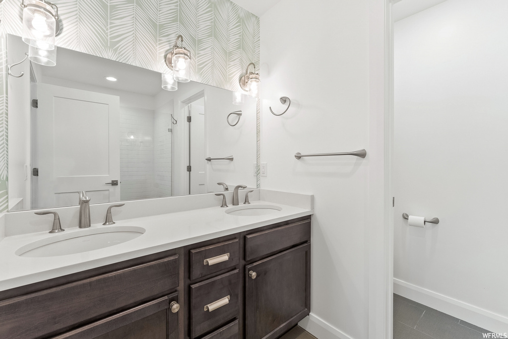 Bathroom with tile flooring, multiple mirrors, and double large vanity