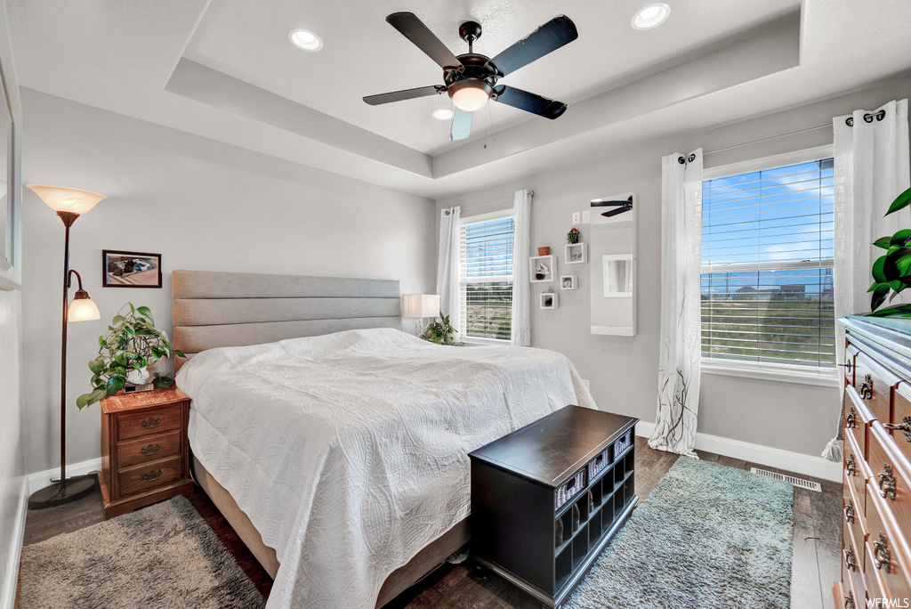 Bedroom with a ceiling fan and multiple windows
