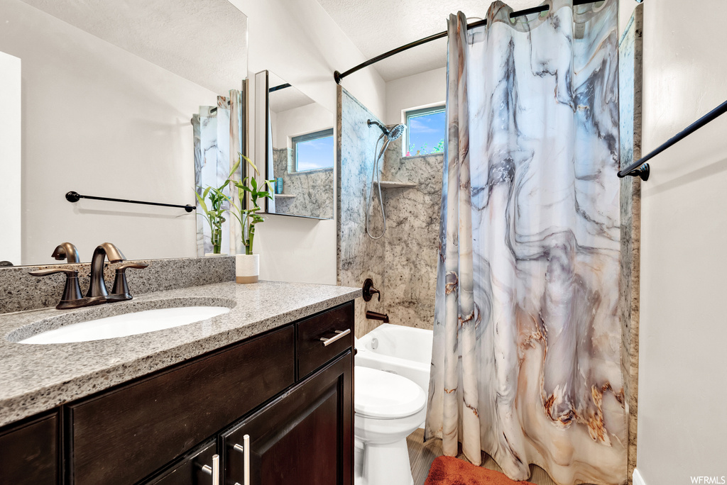Full bathroom featuring shower curtain, vanity, shower / bath combination, mirror, and toilet