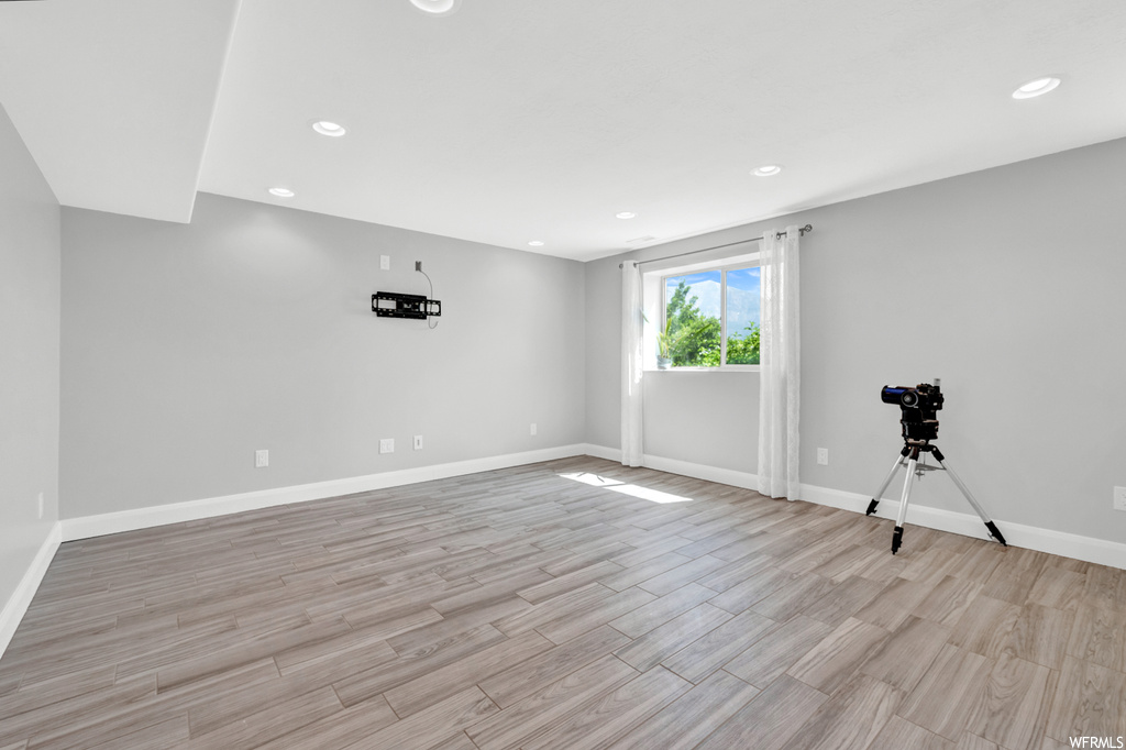 Empty room featuring natural light and hardwood flooring