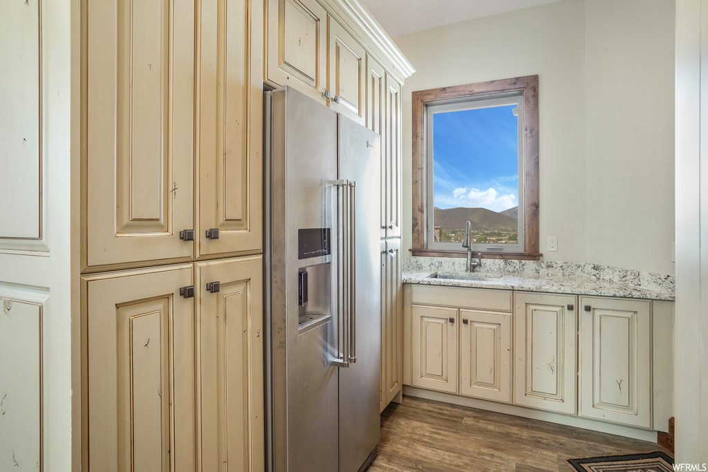 Kitchen with refrigerator, light hardwood floors, and light granite-like countertops