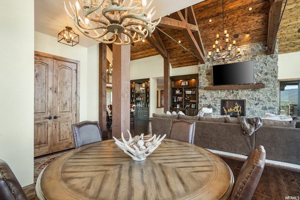 Hardwood floored dining area featuring a notable chandelier, a fireplace, and TV