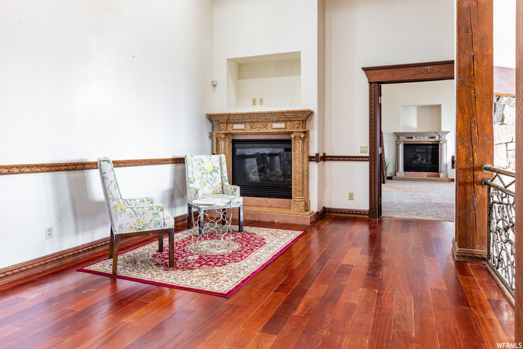 Living area with dark hardwood / wood-style floors and a towering ceiling