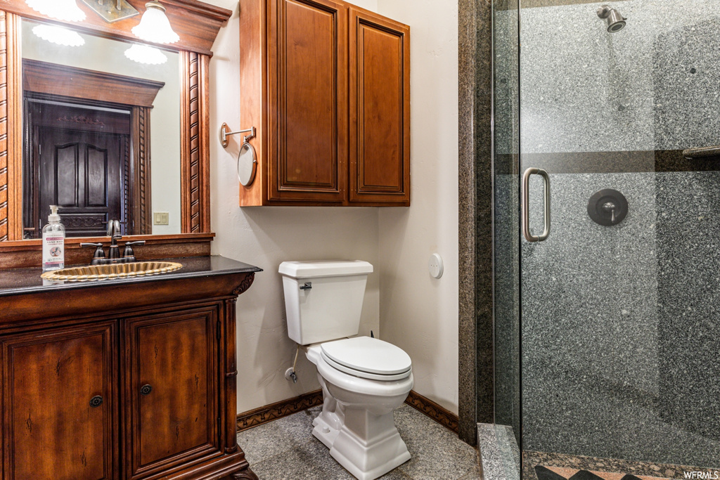 Bathroom featuring walk in shower, toilet, and vanity