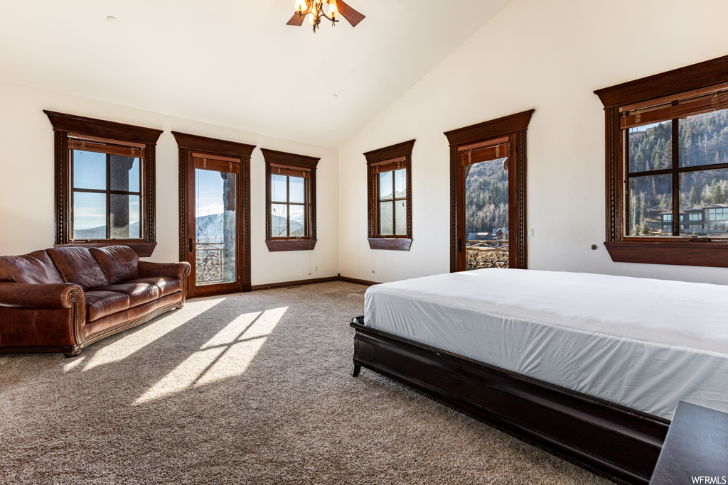 Bedroom with ceiling fan, high vaulted ceiling, carpet flooring, and access to exterior