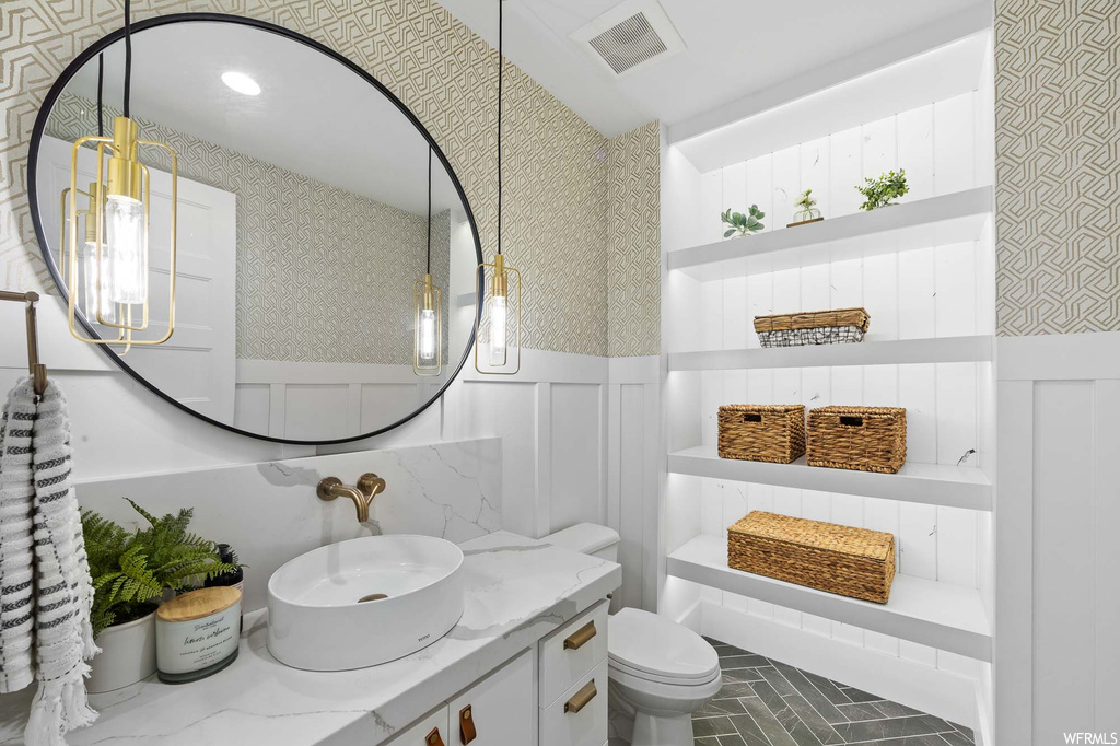 Half bathroom featuring tile floors, mirror, toilet, and oversized vanity