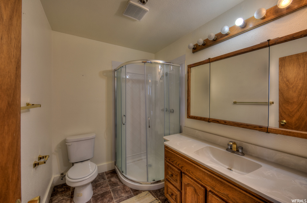 Full bathroom featuring tile floors, mirror, toilet, shower booth, and oversized vanity