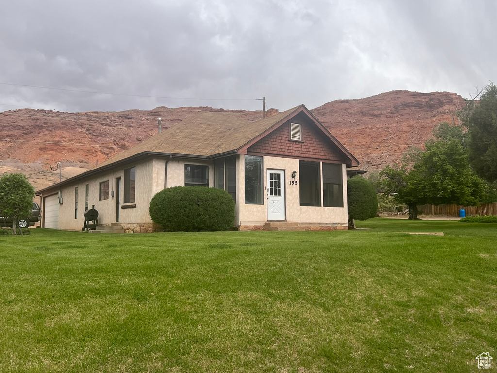 View of front of home with a garage, a mountain view, a front yard, and entry steps