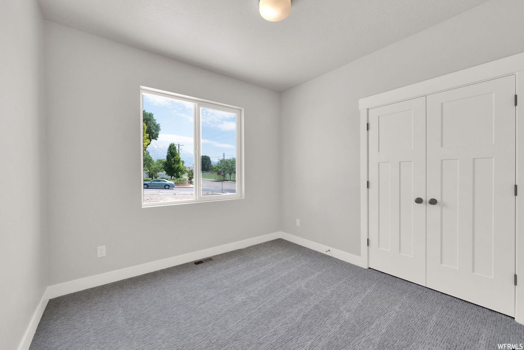 Carpeted spare room featuring natural light