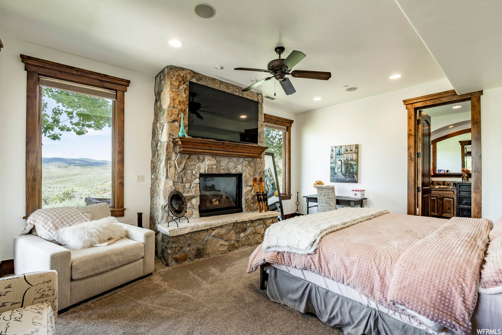 Carpeted bedroom featuring a fireplace, a ceiling fan, natural light, and TV