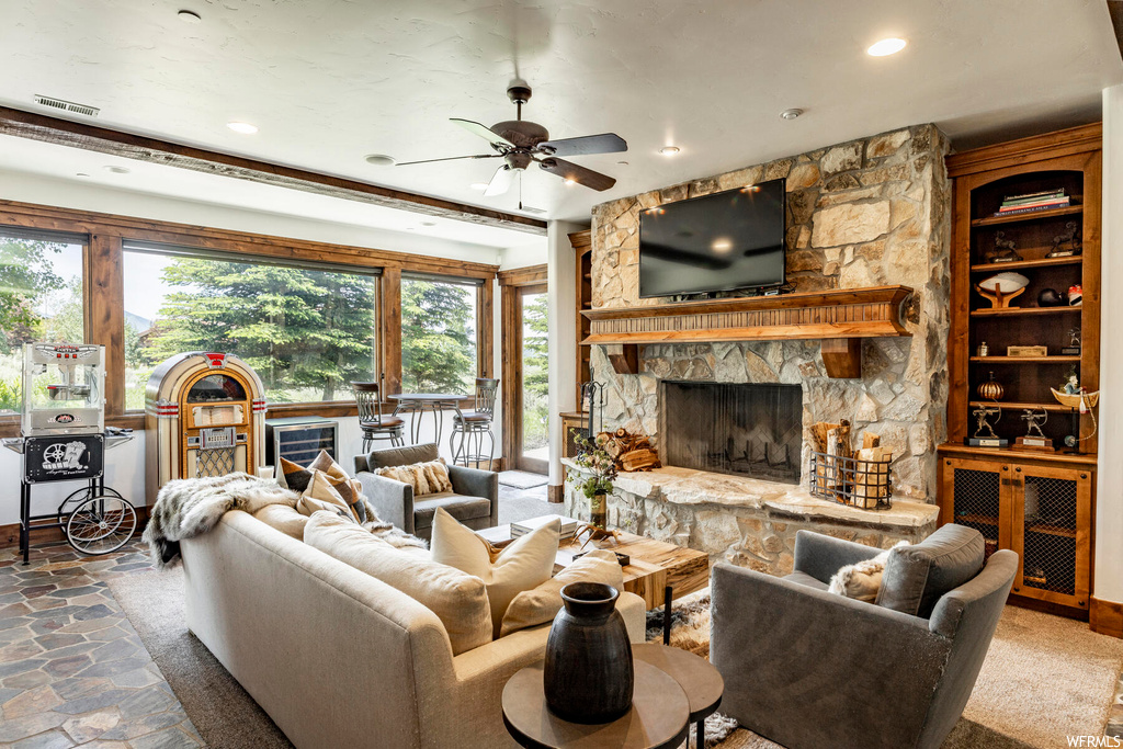 Living room featuring a fireplace, a ceiling fan, natural light, and TV