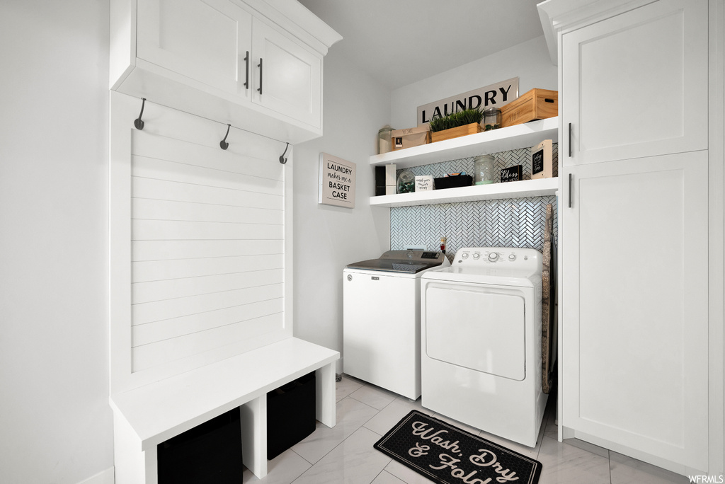 Mudroom with tile flooring and separate washer and dryer