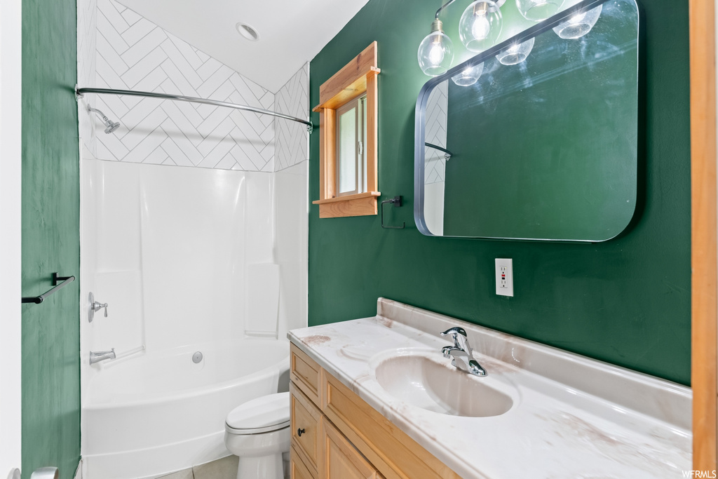 Full bathroom featuring natural light, mirror, toilet, bathing tub / shower combination, and vanity