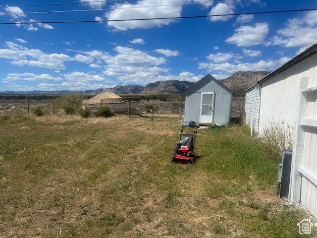 View of yard with a mountain view and a storage shed