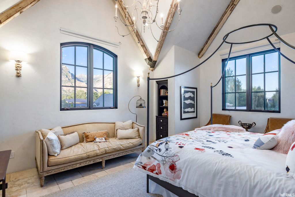 Bedroom featuring vaulted ceiling with beams and natural light