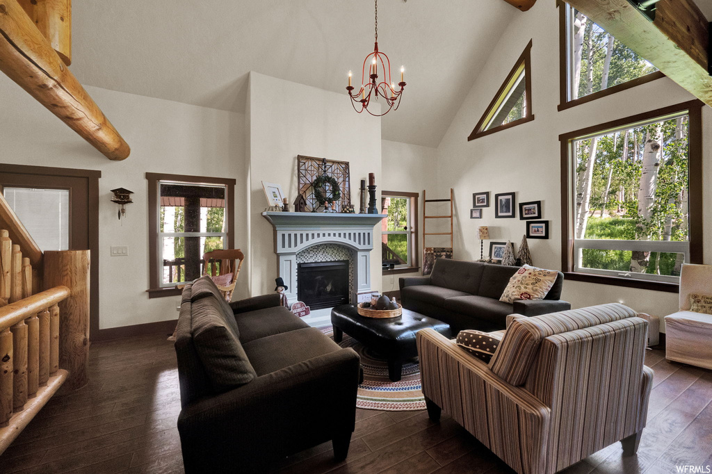 Living room featuring a fireplace, vaulted ceiling with beams, a high ceiling, and natural light