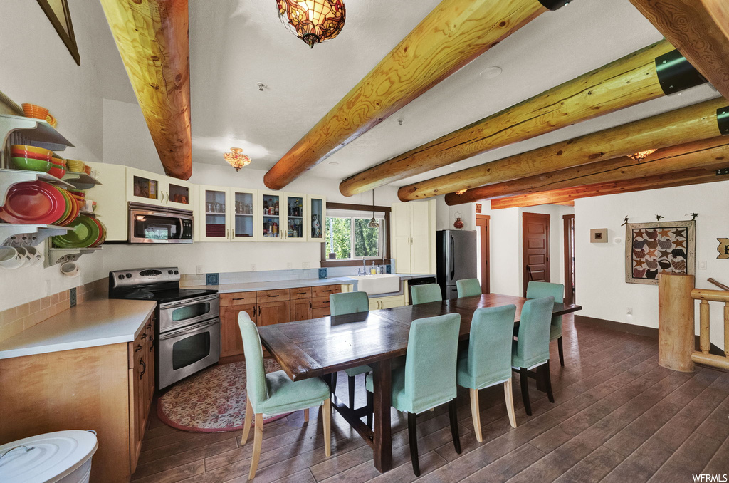 Hardwood floored dining area featuring beamed ceiling, natural light, and microwave