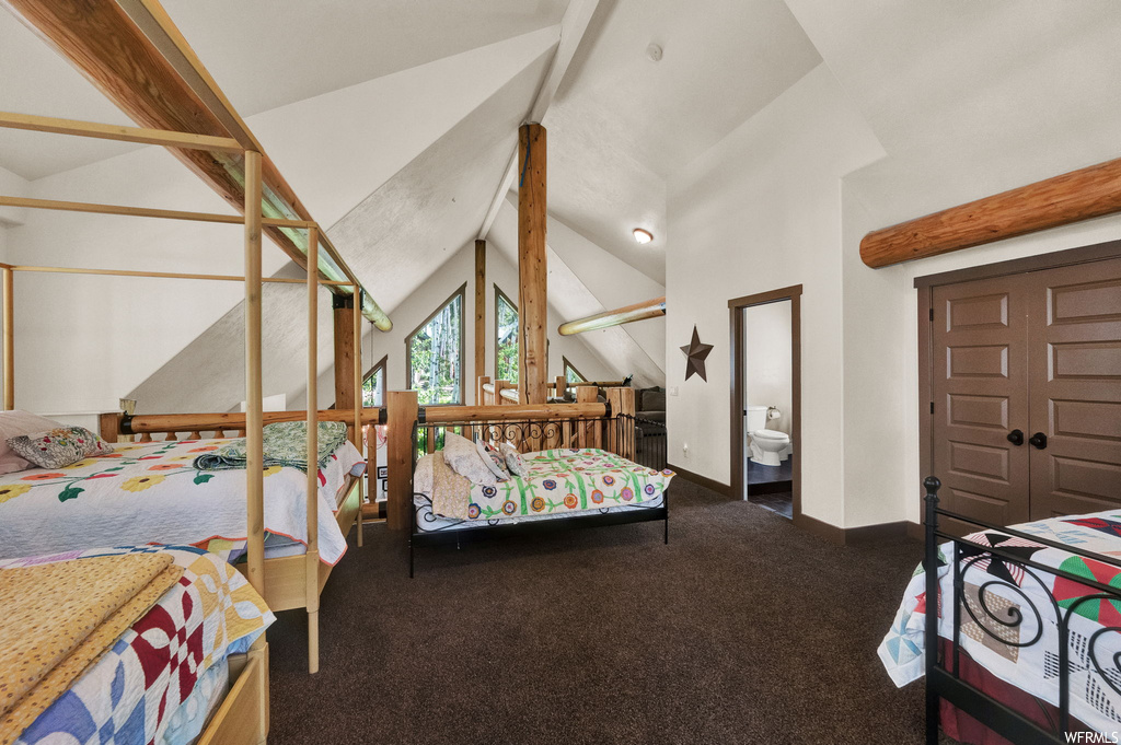Bedroom with lofted ceiling with beams and carpet