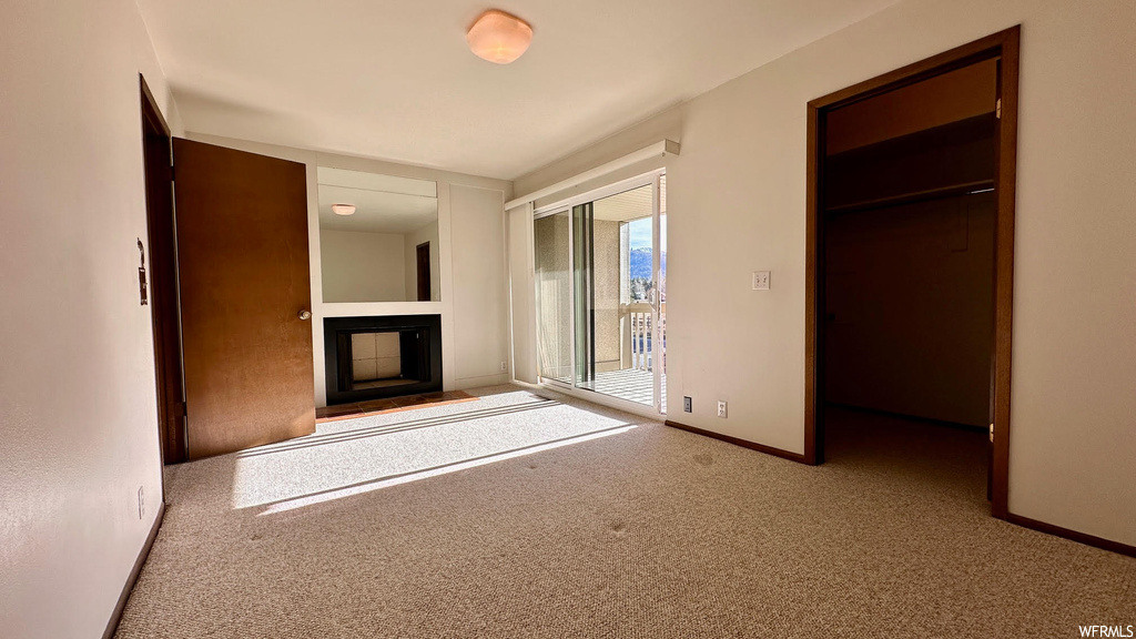 Unfurnished bedroom with access to outside, a closet, and light carpet