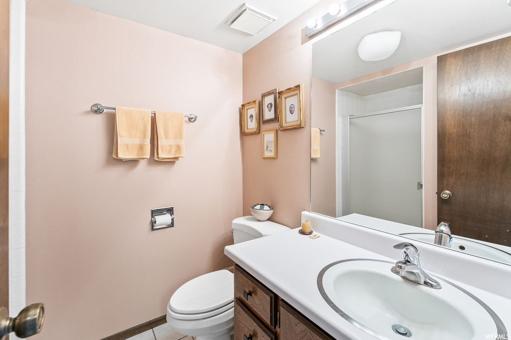 Half bathroom with mirror, toilet, and vanity