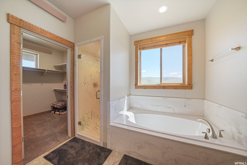 Bathroom featuring natural light and independent shower and bath