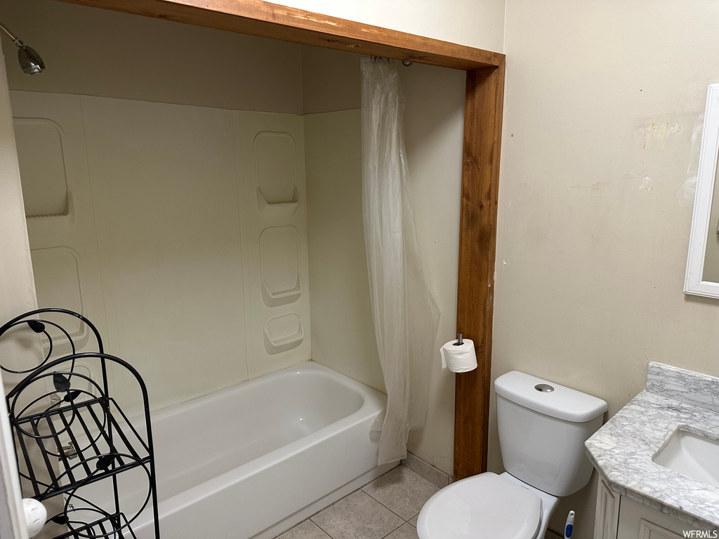 Full bathroom with vanity, shower / bath combo, and light tile floors