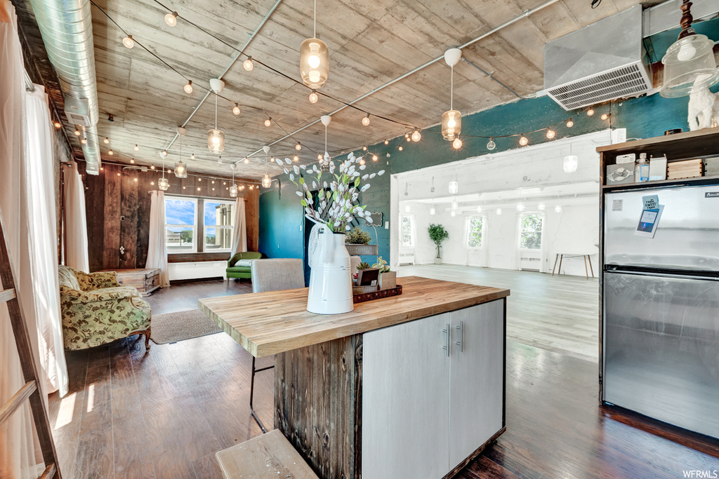 Kitchen featuring natural light, refrigerator, light countertops, pendant lighting, and light parquet floors