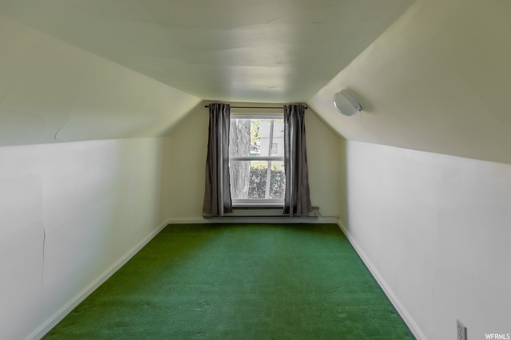 Additional living space featuring vaulted ceiling and natural light