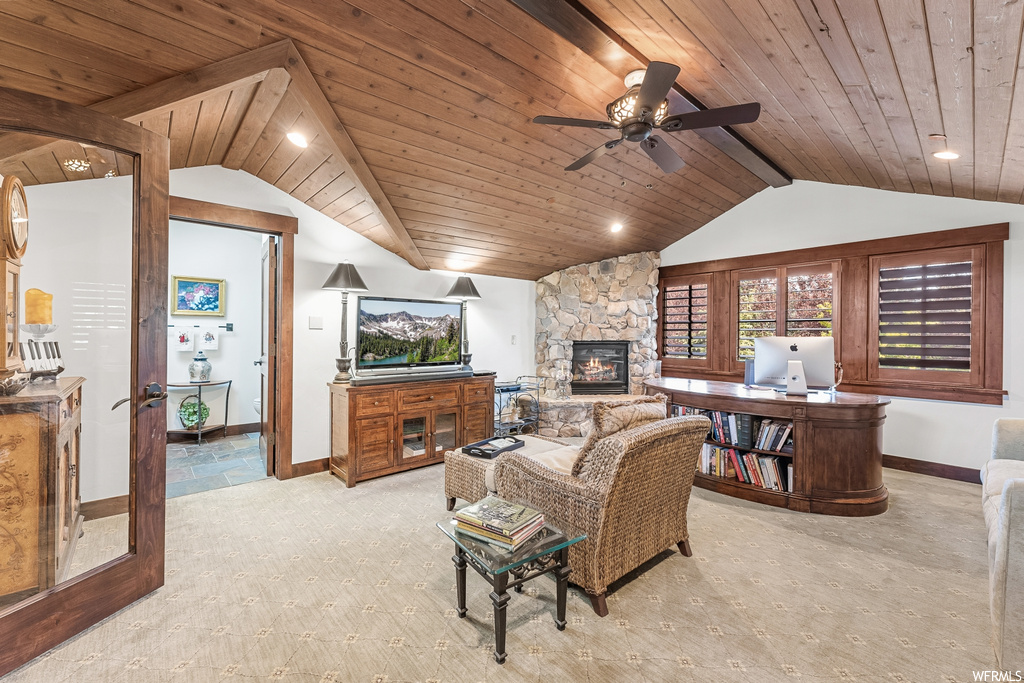 Living room featuring a ceiling fan, natural light, carpet, lofted ceiling, a fireplace, and TV