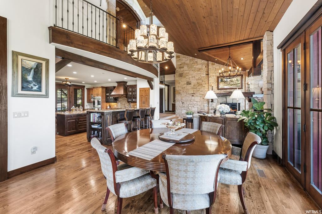 Hardwood floored dining room with a breakfast bar area and a notable chandelier