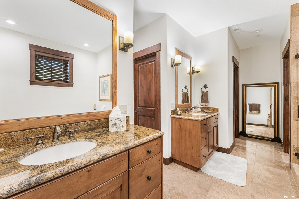 Bathroom with tile flooring, dual vanity, and mirror