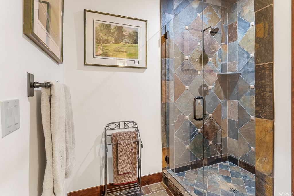Bathroom with tile flooring and shower with shower door