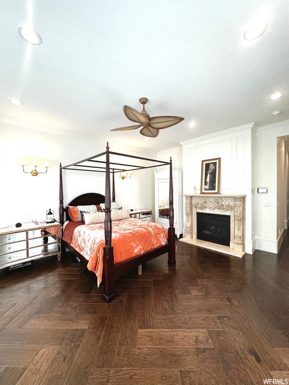 Hardwood floored bedroom featuring a fireplace and a ceiling fan