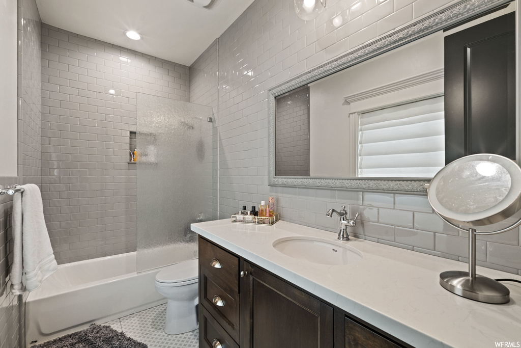 Full bathroom featuring bath / shower combination, mirror, toilet, and vanity with extensive cabinet space