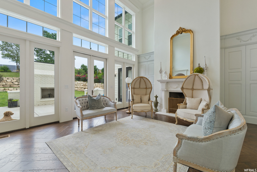 Sitting room featuring natural light, french doors, a high ceiling, and a fireplace