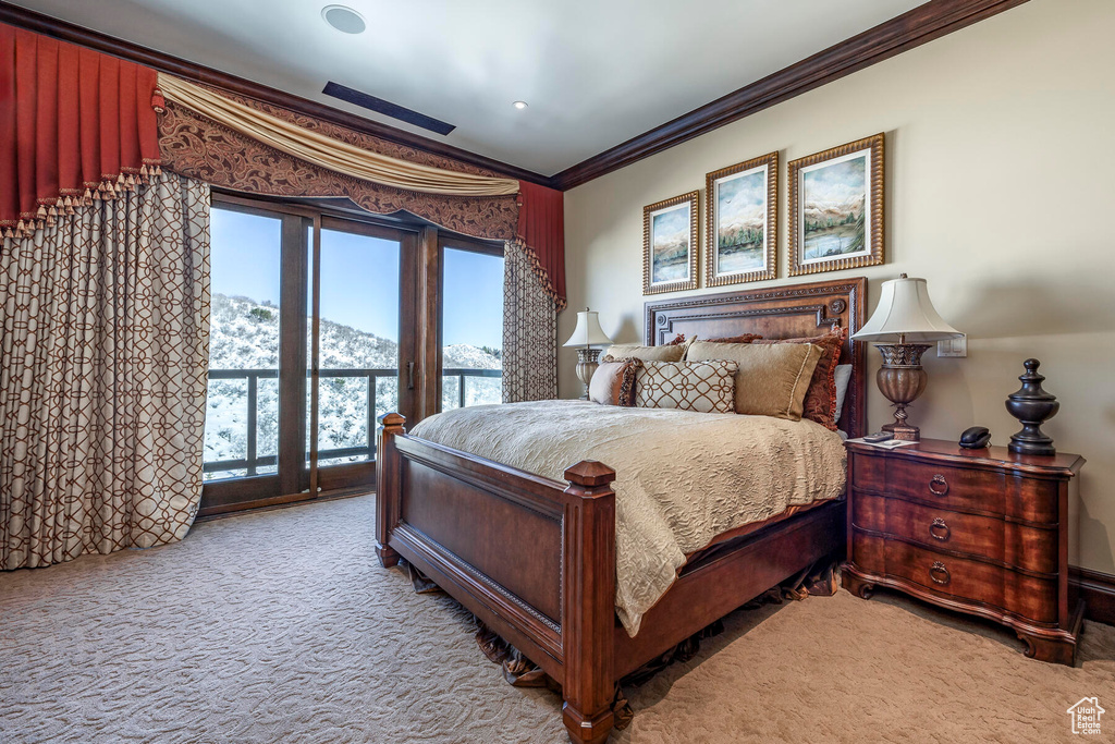 Carpeted bedroom featuring crown molding and access to exterior