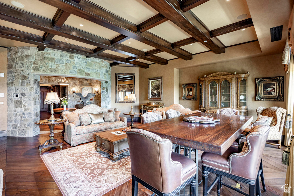 Dining room featuring coffered ceiling, beamed ceiling, and dark hardwood / wood-style flooring
