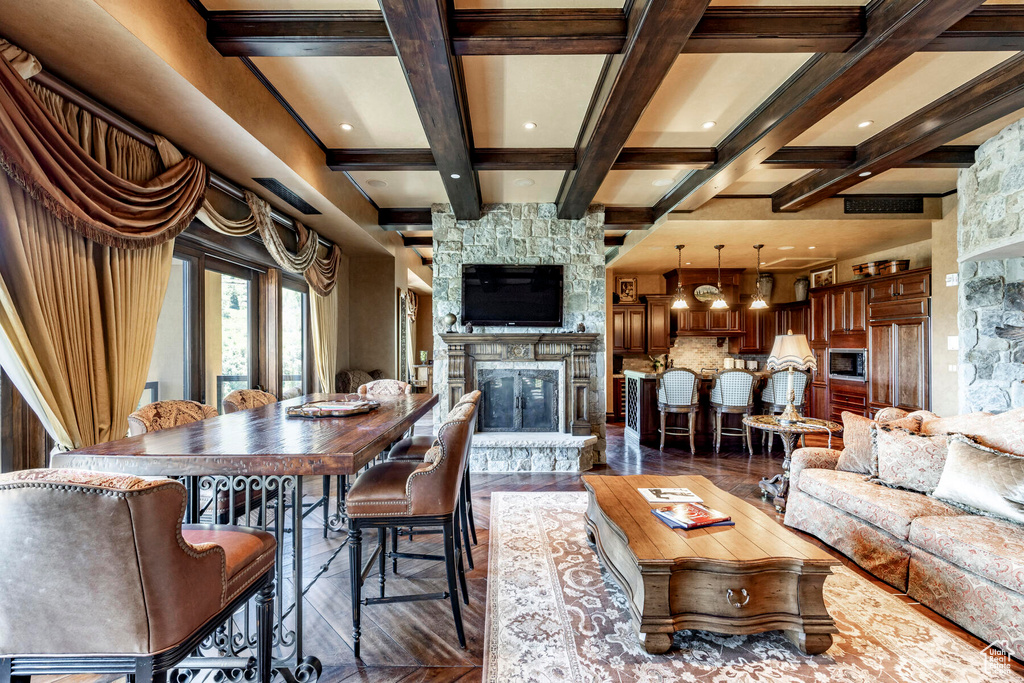 Living room with a stone fireplace, coffered ceiling, and beam ceiling