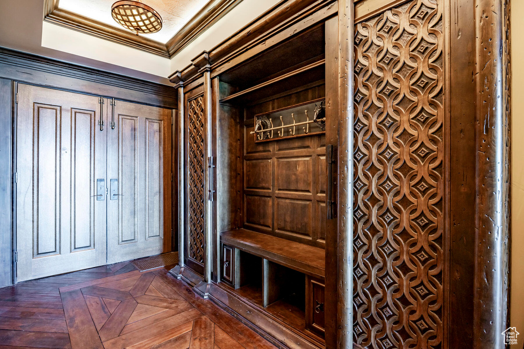 Mudroom featuring ornamental molding, a raised ceiling, and dark parquet floors