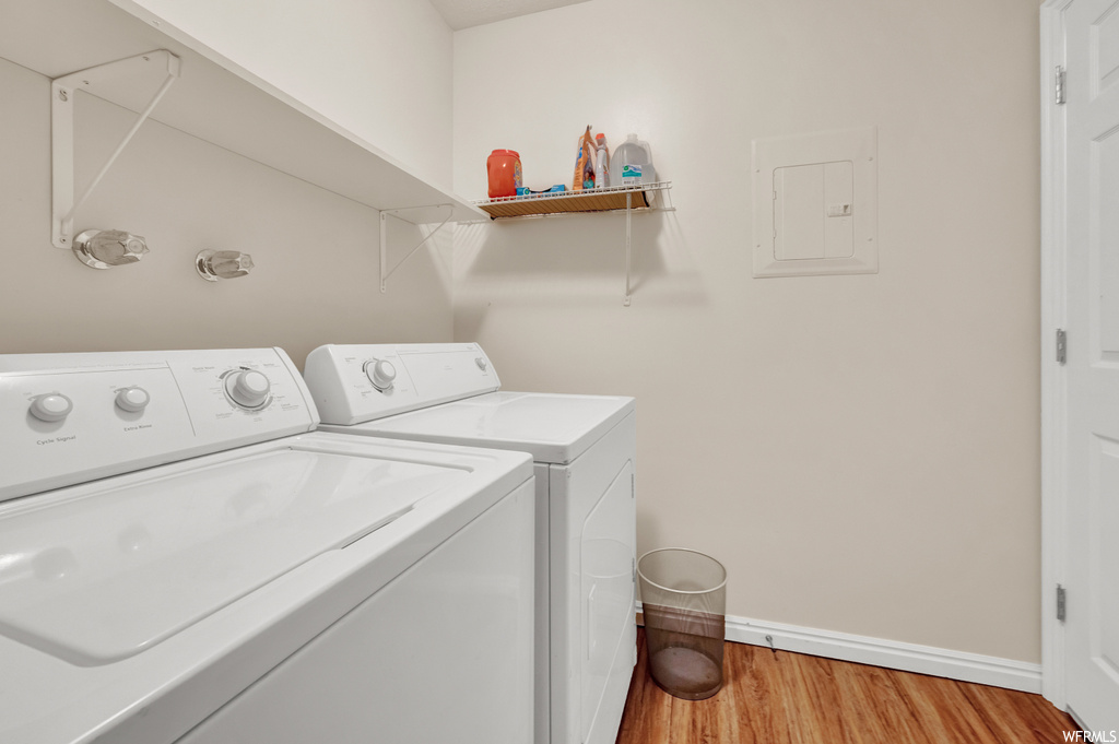 Laundry area with hardwood flooring and independent washer and dryer