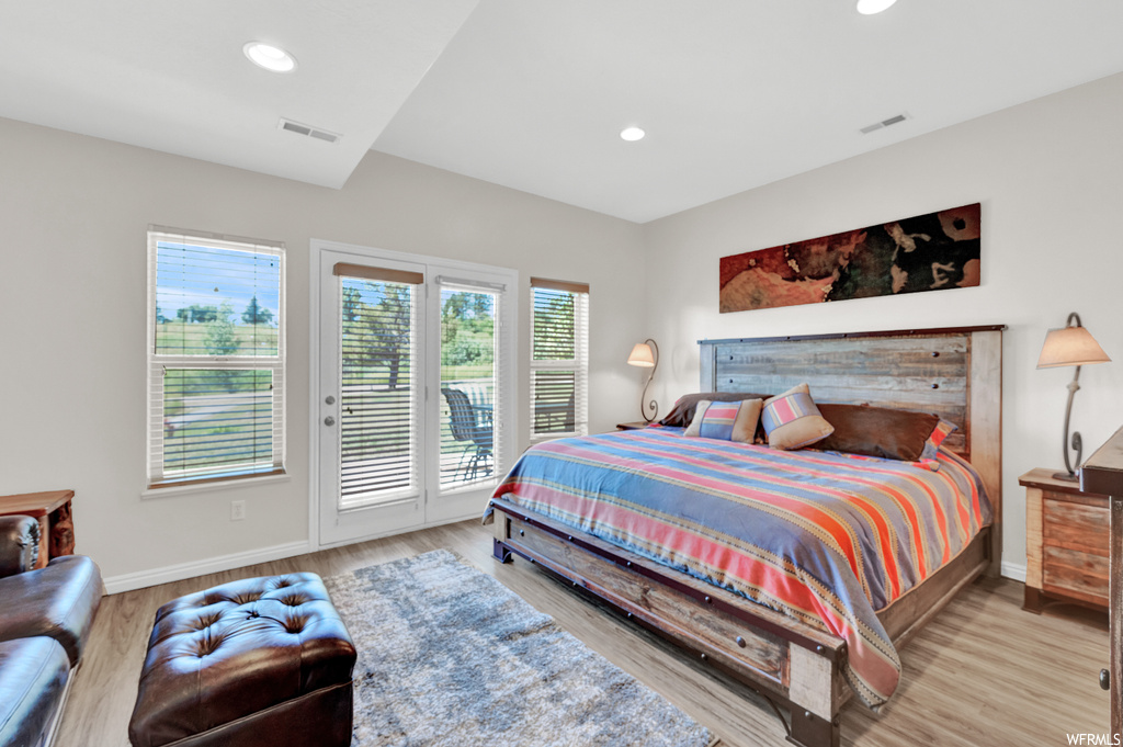Bedroom featuring multiple windows and hardwood flooring