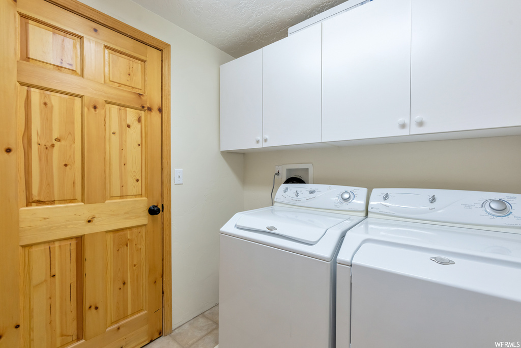 Laundry area with tile floors and separate washer and dryer