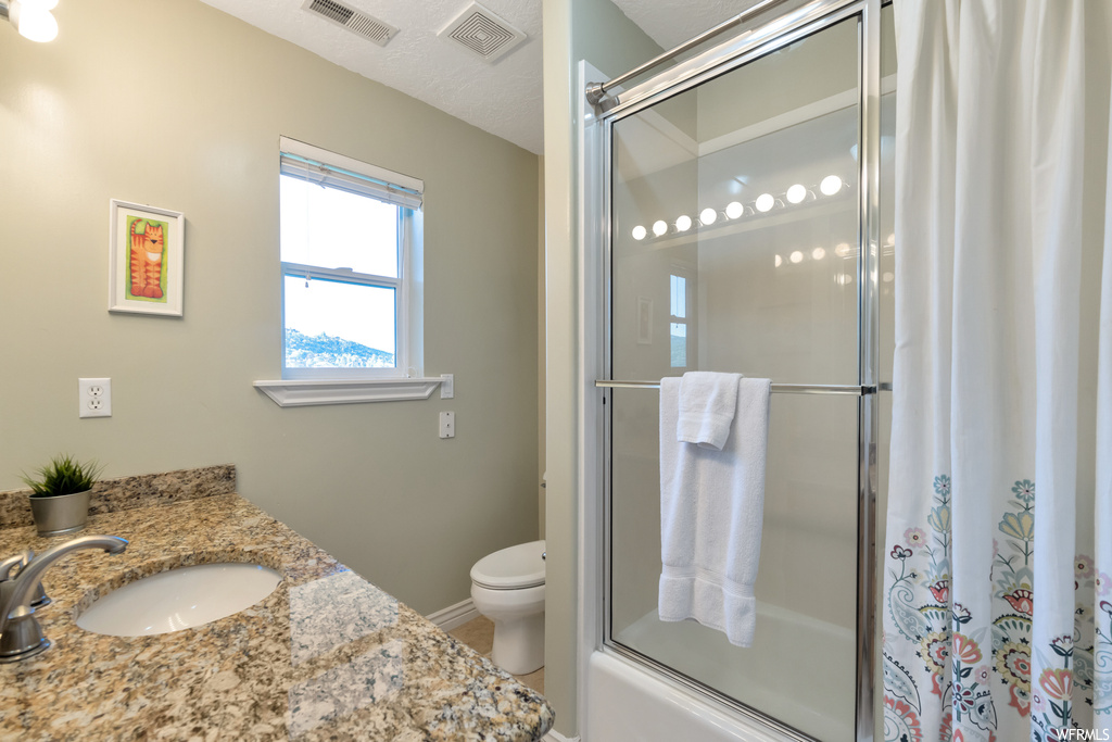 Full bathroom featuring natural light, vanity, toilet, shower curtain, and shower / washtub combination