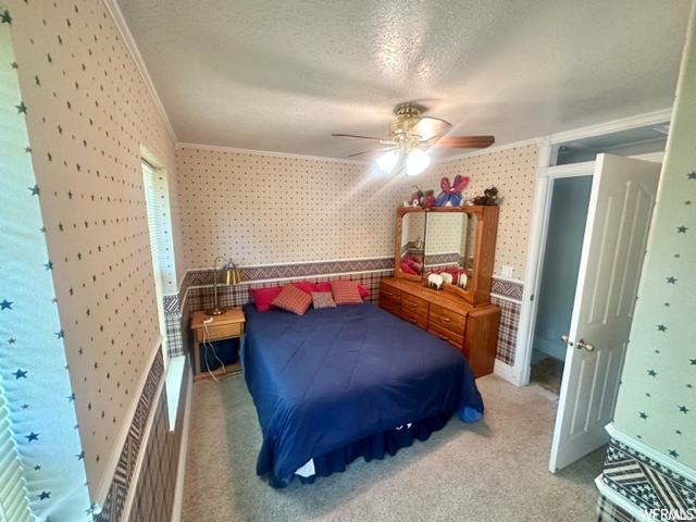 Carpeted bedroom featuring a ceiling fan