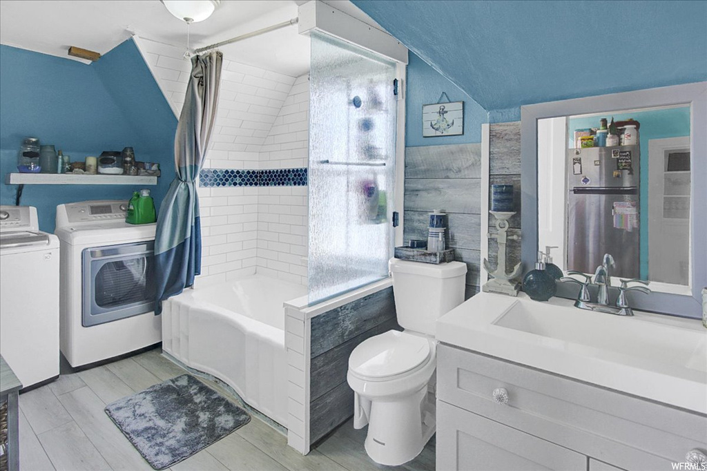 Bathroom with independent washer and dryer, mirror, toilet, shower curtain, and vanity